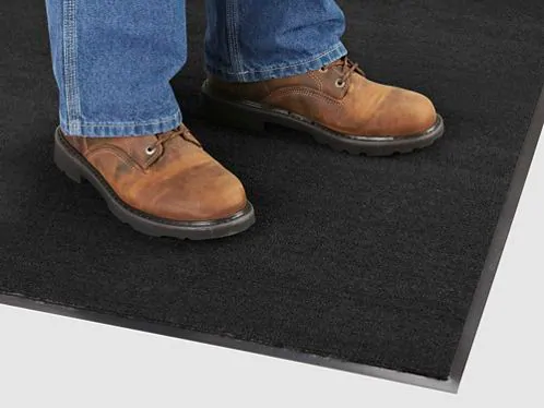 Man standing on a cleaned floor mat in an office entrance.